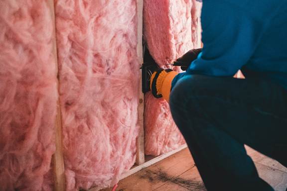 Technician performing attic insulation installation in California