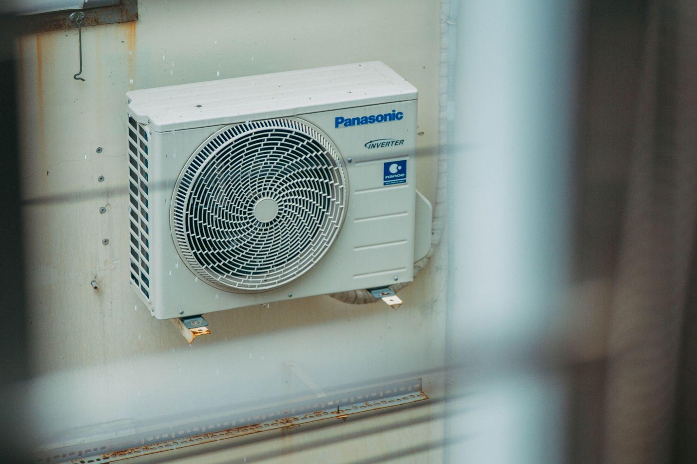 Outdoor air conditioner condenser beside a home