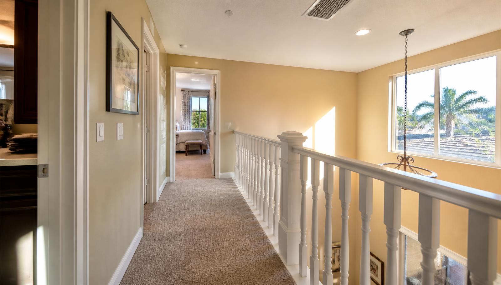 Upstairs hallway of a two-story Modesto home with afternoon sun and a ceiling supply vent