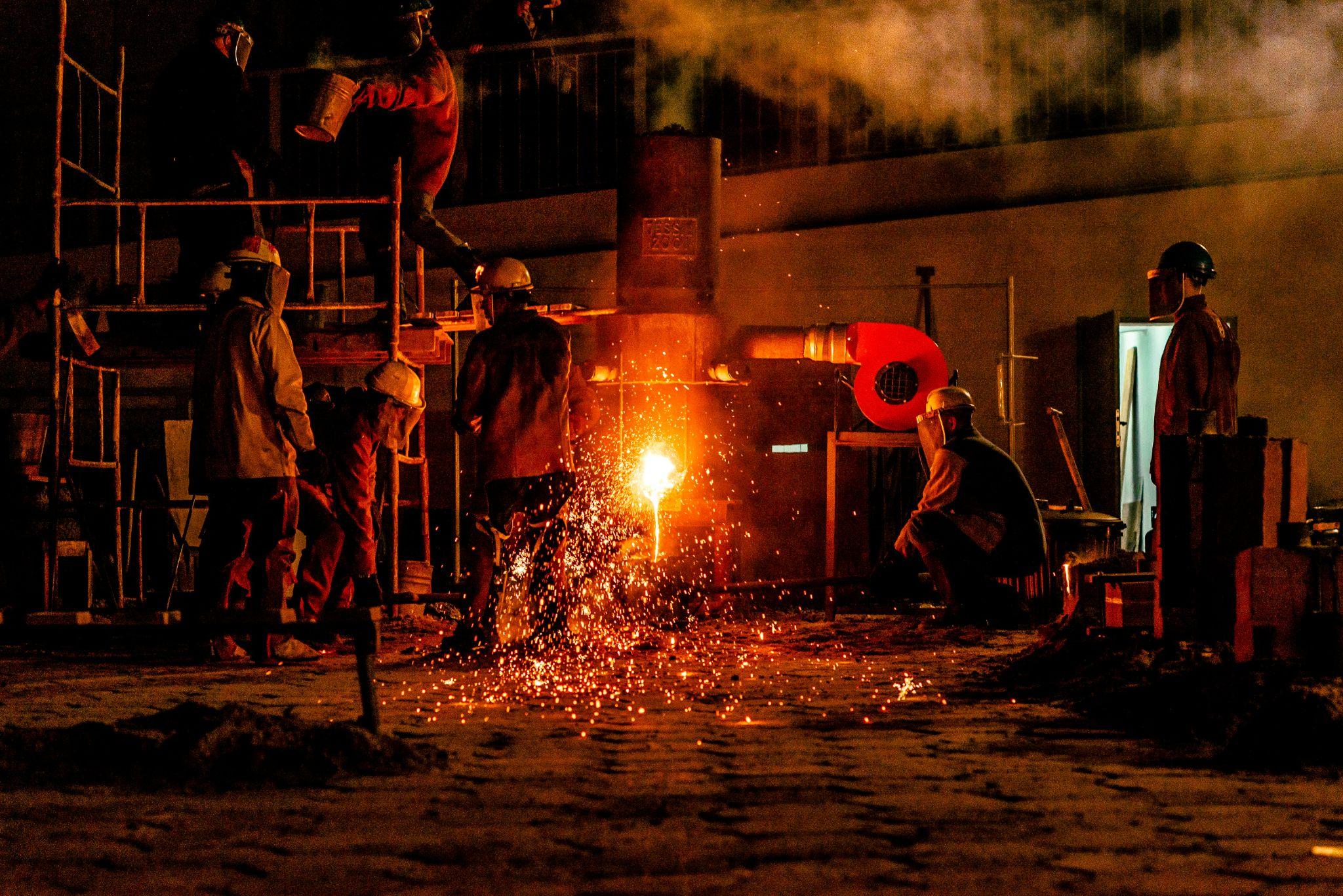 Industrial workers operate a furnace in a factory, illustrating the importance of reliable furnace repair in Turlock.