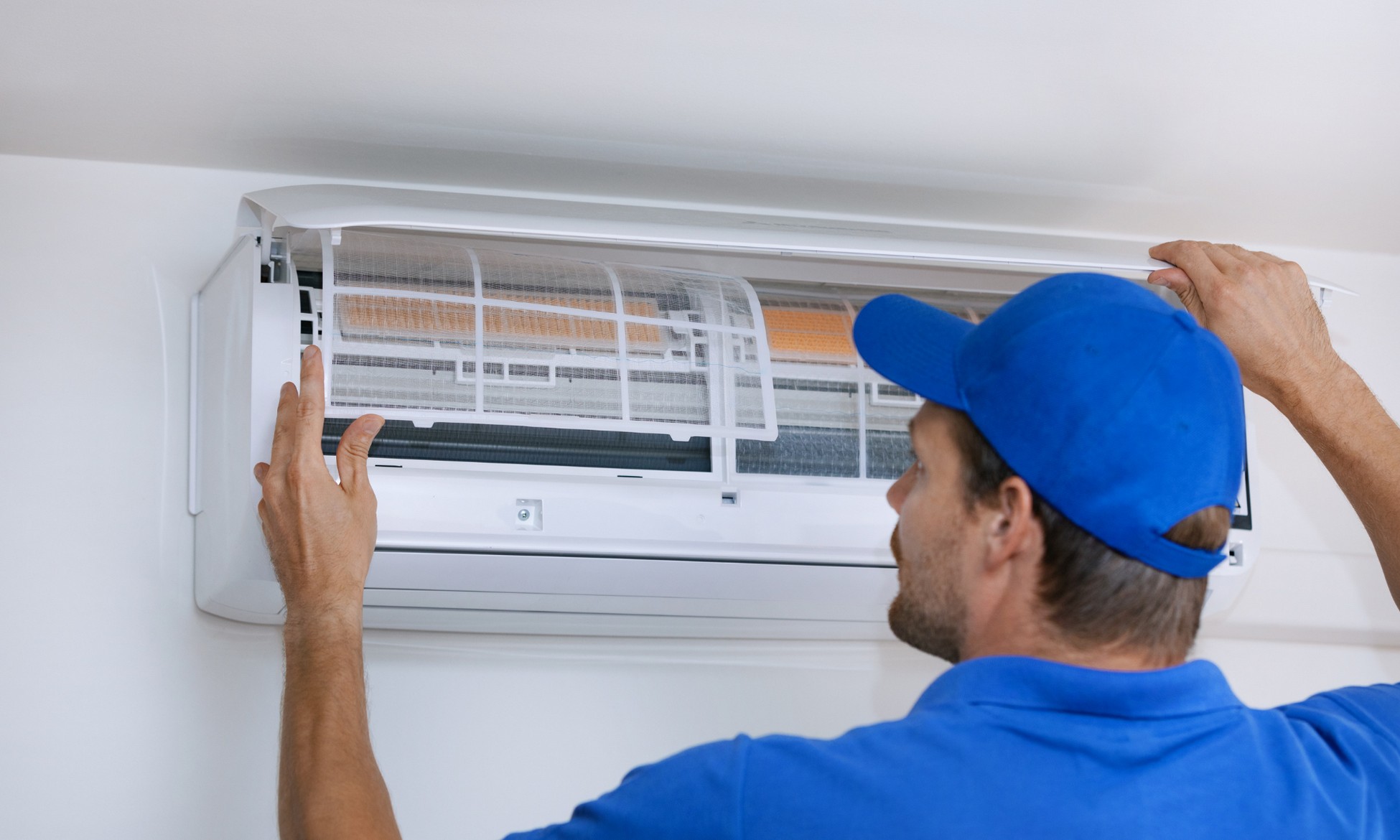 Technician inspecting an air conditioning unit as part of professional HVAC services in California.