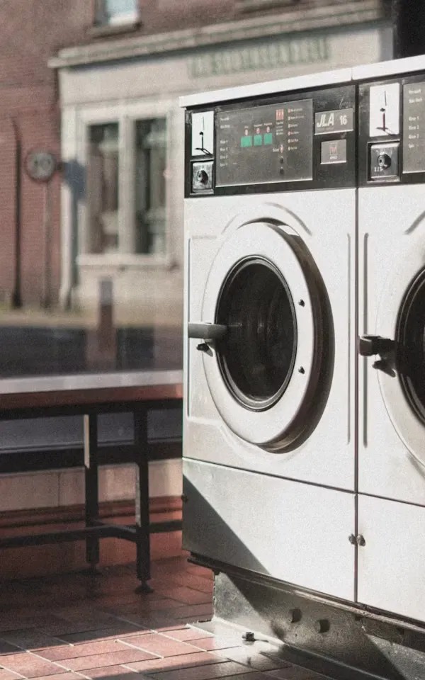 Row of front-load washing machines at a laundromat storefront
