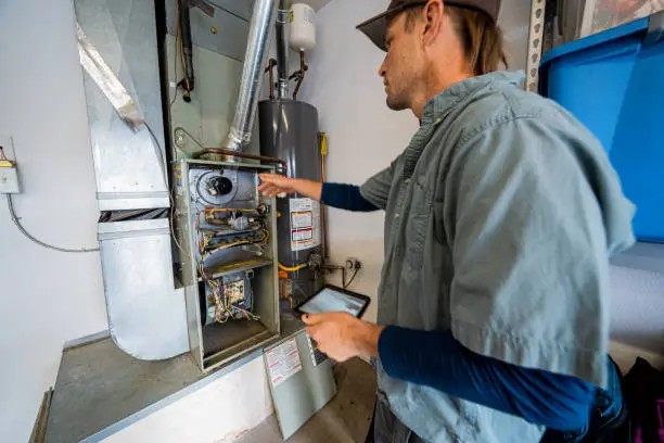 Close-up of a technician offering furnace repair in California with tools and exposed mechanical parts.