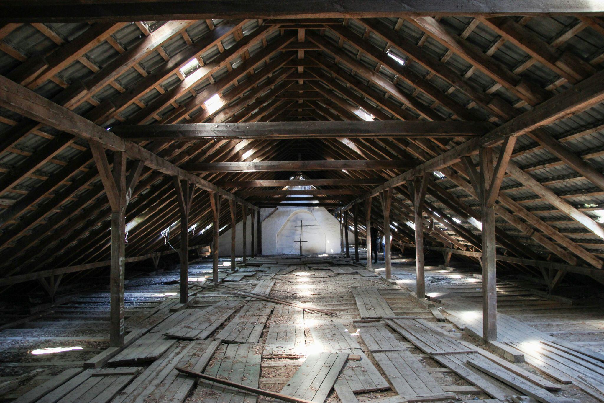 An attic space is evaluated by attic insulation contractors in California for insulation needs.
