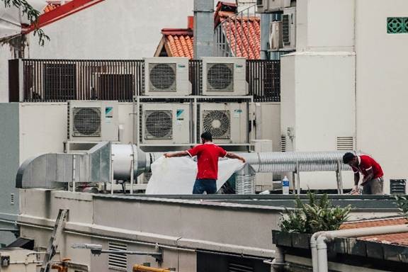 Technician performing air conditioning repair in California