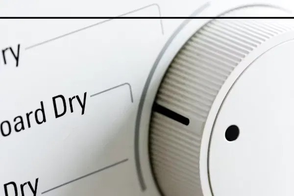 Close-up of a dryer control dial showing drying cycle settings