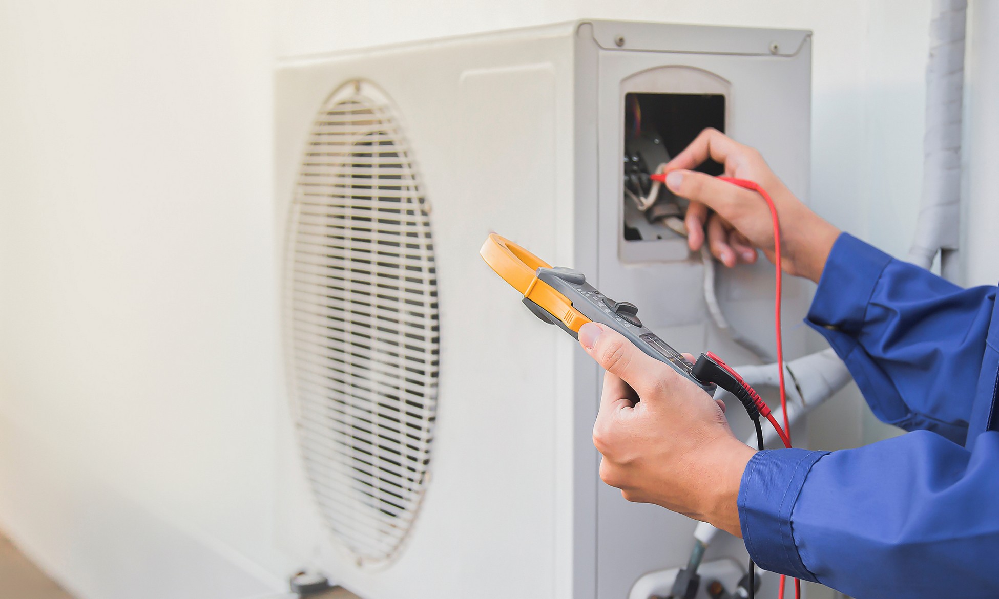 Technician testing an air conditioning unit as part of professional HVAC repair services in California.