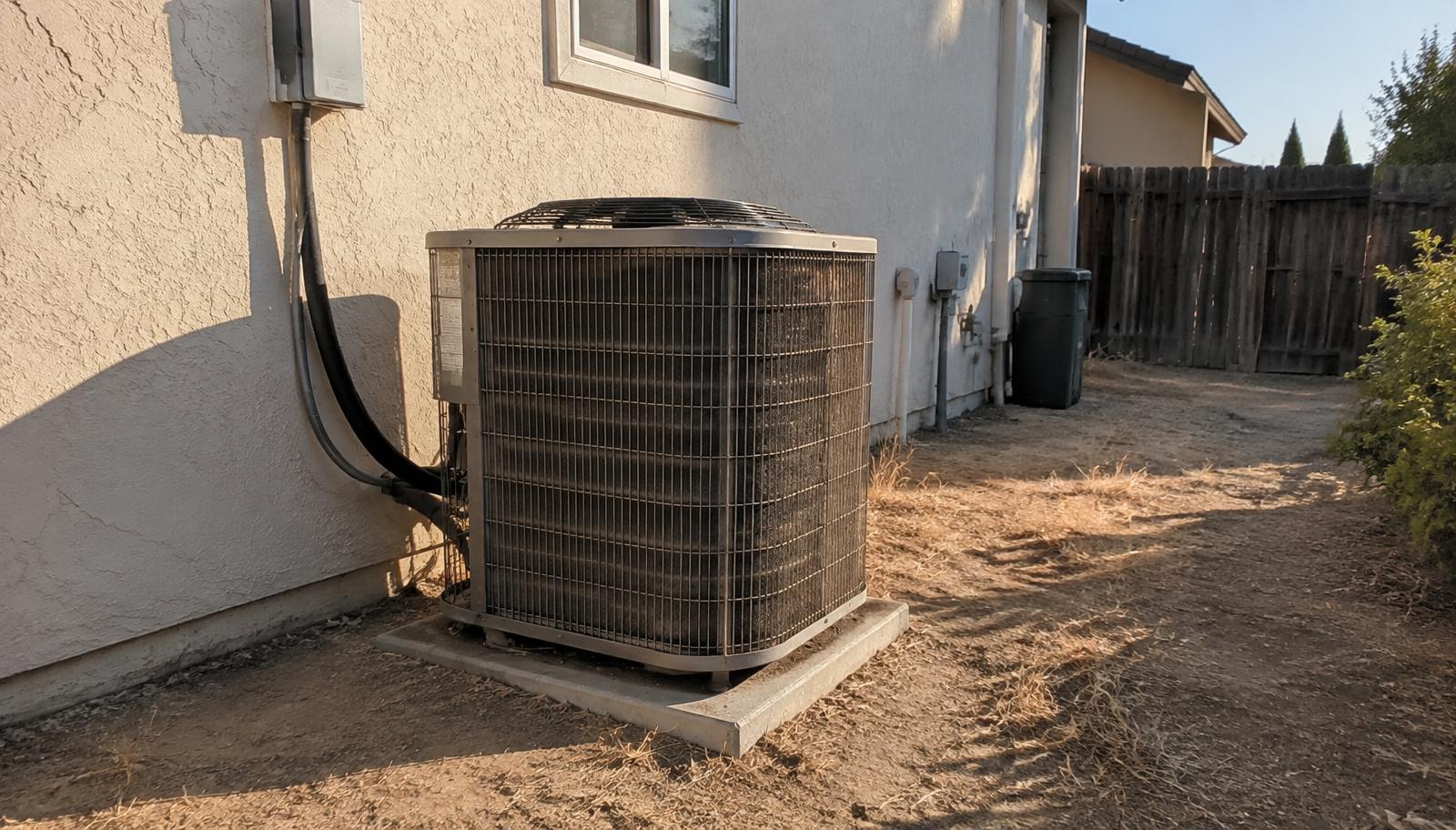 Dust-covered outdoor AC condenser unit beside a Salida, CA home near the Highway 99 corridor