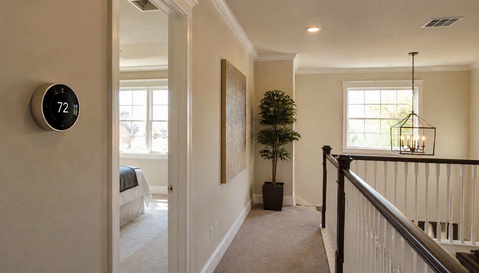 Upstairs hallway of a two-story Salida home with a programmable thermostat on the wall